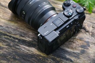 Sony A7CR camera with a lens attached sat on a wooden log