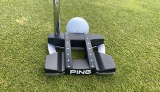 Ping 2022 Tomcat 14 Putter on a green background and against a golf ball