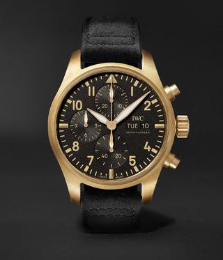 Black IWC watch with gold case against a black background