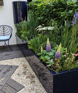 Seating and raised flower beds on The Water Saving Garden at the RHS Chelsea Flower Show 2024