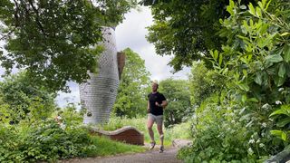 TechRadar fitness writer Harry Bullmore running by a statue of a fish