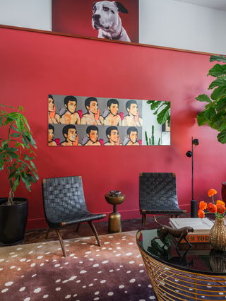 A bright red wall with artworks on it