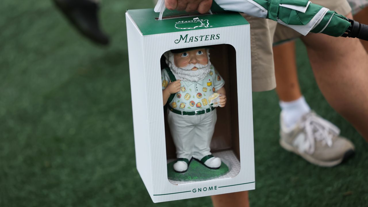 A patron walks along with their 2025 Masters gnome