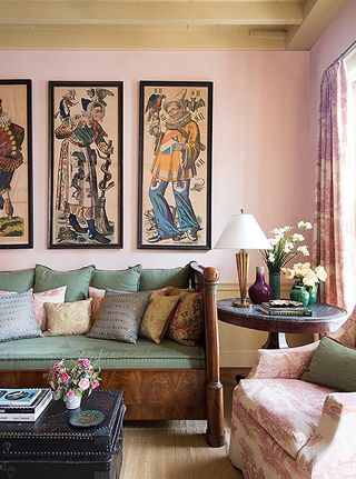 Pink walls, green and wooden sofa