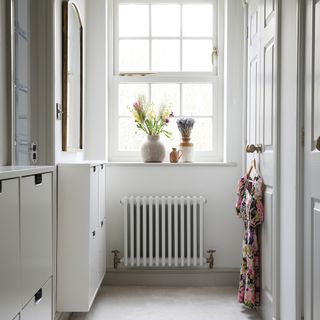 a hallway or dressing area with a window and lots of built-in wall-hung storage