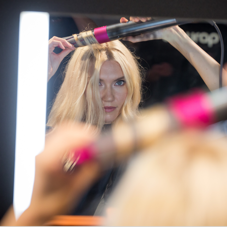 A model demonstrates Dyson Ltd.'s Airwrap product during the company's beauty technology launch event in New York, U.S., on Tuesday, Oct. 9, 2018. Dyson develops and manufactures vacuum cleaners, hand dryers, fans, and groom tools. 