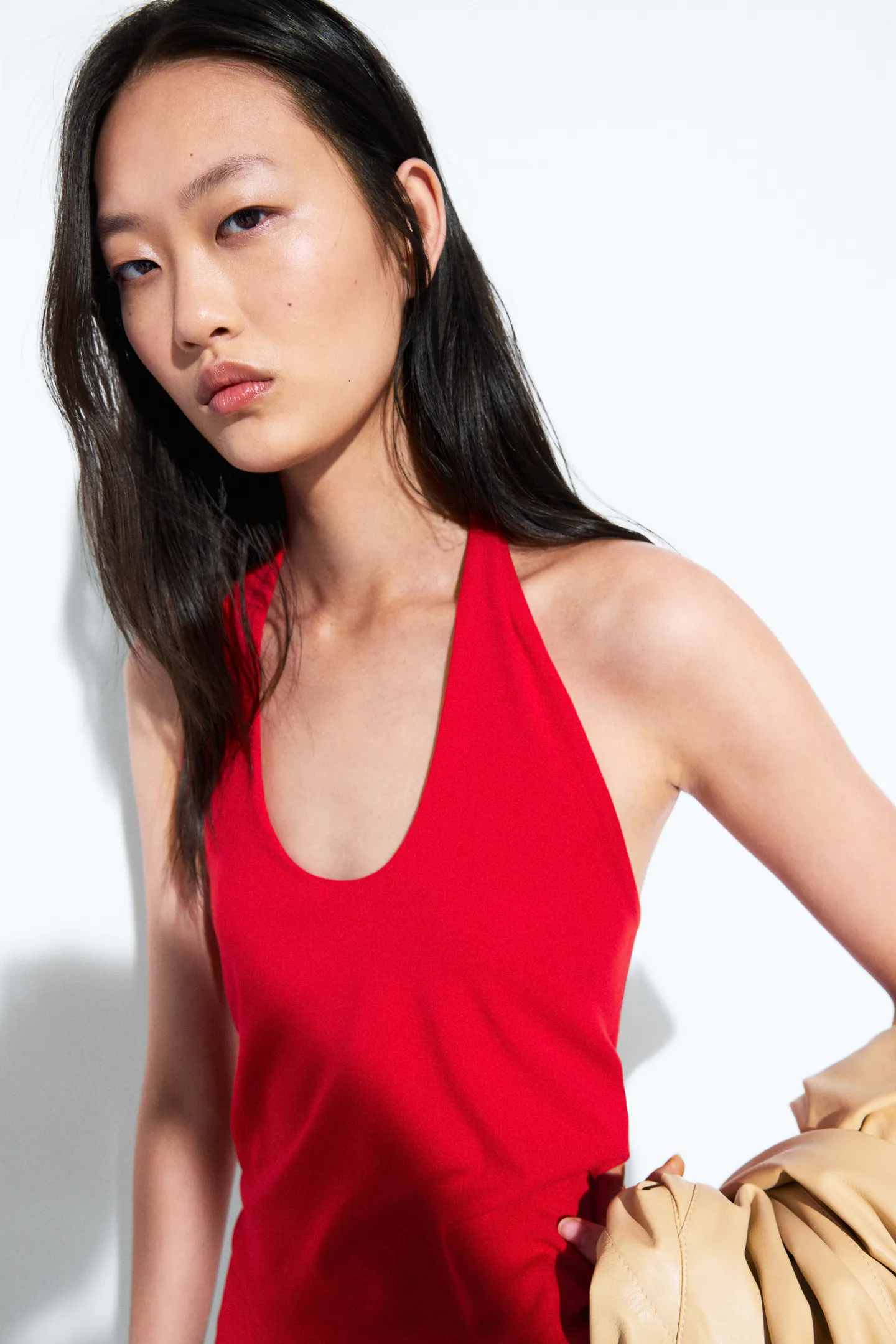 A model wearing a red Massimo Dutti halterneck top.