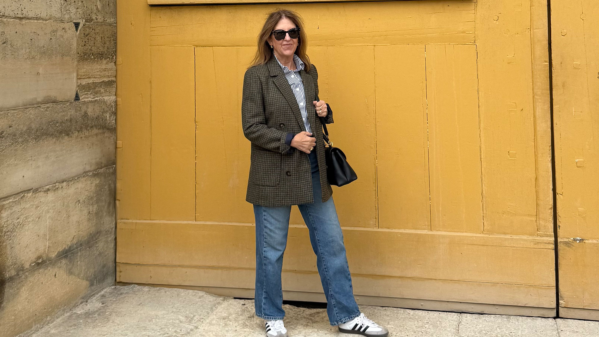 A Nordstrom stylist wearing an oversize blazer, jeans, and Adidas sneakers. 