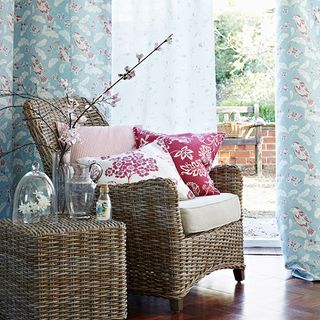 rattan armchair with cushions and duck egg blue curtains