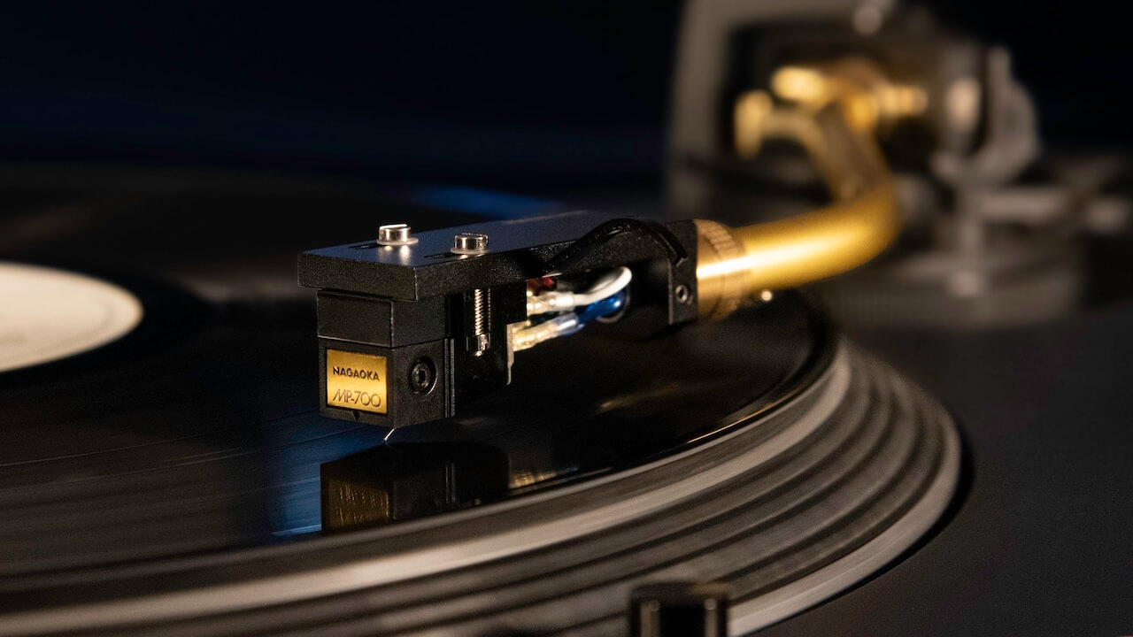 Close up of a turntable with a Nagaoka MP-700 cartridge playing a vinyl record.