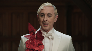 Alan Cumming in white tux with red flowers in The Traitors Season 3 episode 7 roundtable