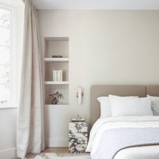 A neutral bedroom with a stone bedside table