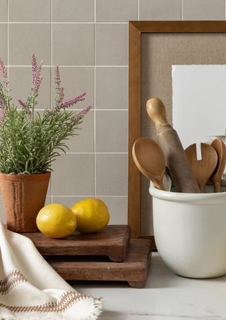 Two stacked wooden pedestals on a kitchen counter with a ceramic bowl next to it