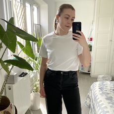 Florrie wears a white clean cut tshirt and Arch jeans from COS