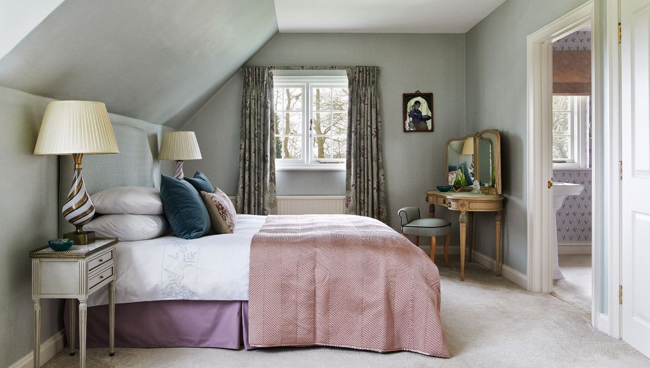 Gray loft bedroom, bed with purple throw and dressing table