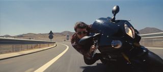 A still from Mission: Impossible – Rogue Nation, showing heavy motion blur in the road and guard rail.