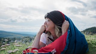 A woman sleeping in sleeping bag outside, bivvying