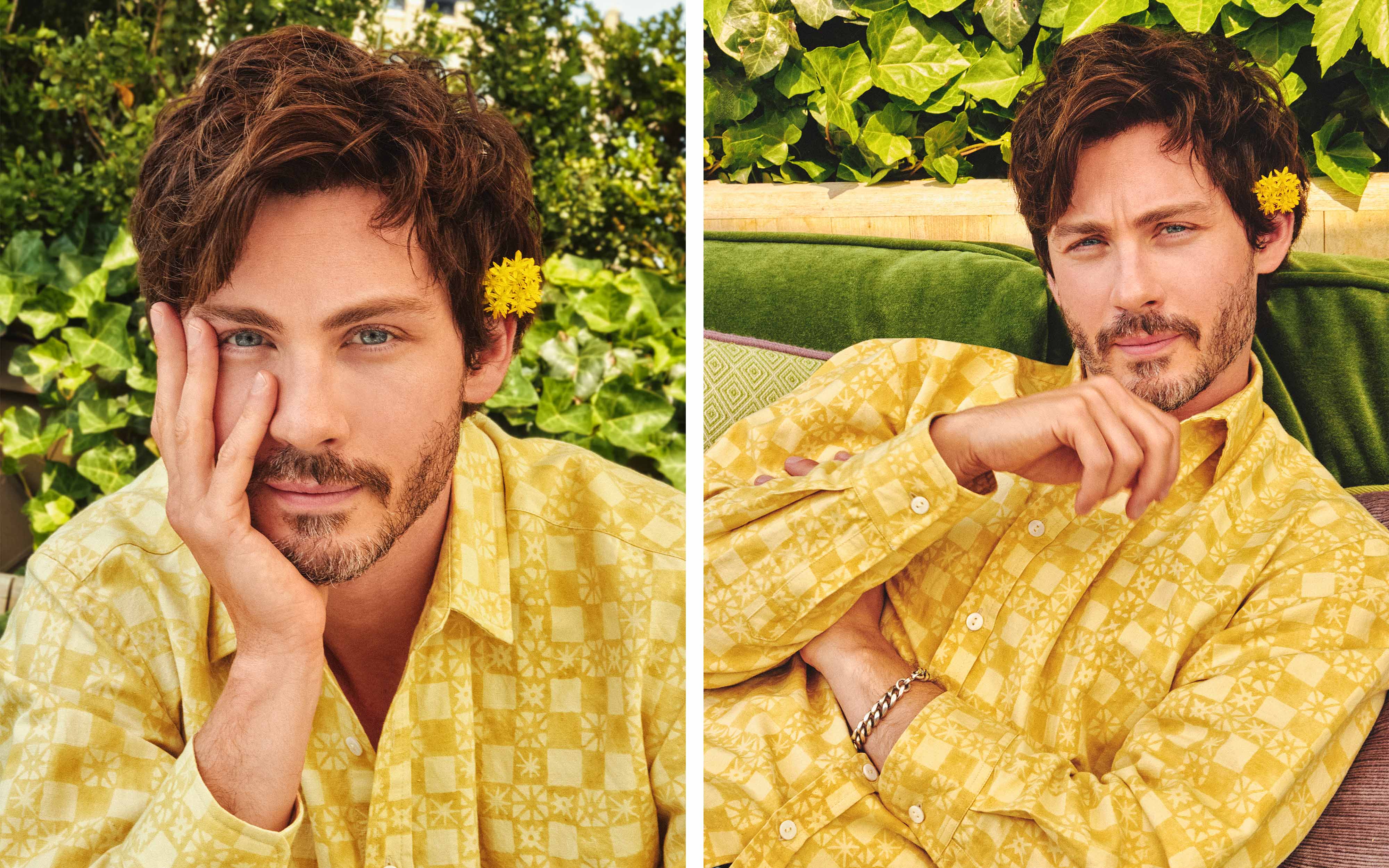 logan lerman wearing a patterned yellow button up against green foliage