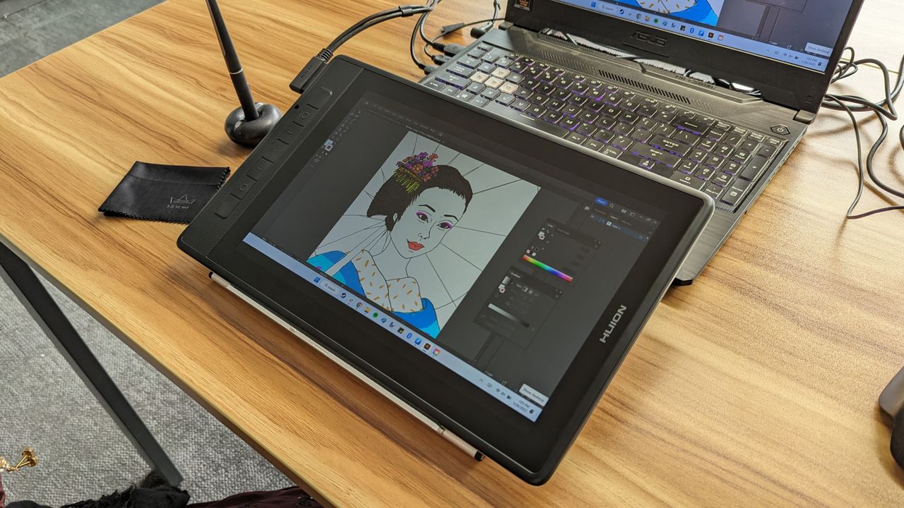 Huion Kamvas Pro 13 2.5K graphics / drawing tablet being used on a wooden table in an office space in the daytime.