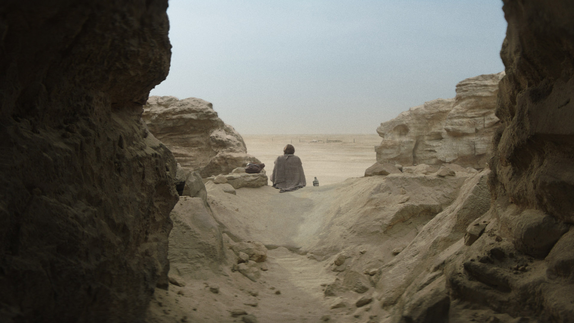 Obi-Wan Kenobi sits alone on a Tatooine cliff edge to eat some food in his Disney Plus show