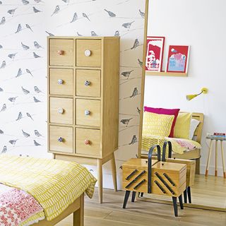 white bedroom with bird wallpaper and wooden flooring
