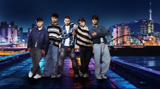 The stars of Made In Korea: The K-Pop Experience stand on a rooftop overlooking the neon skyline of Seoul at night. From left to right: Blaise Noon, Dexter Greenwood, Reese Carter, James Sharp and Olly Quinn