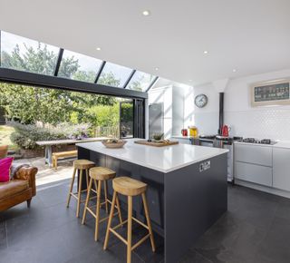 small kitchen extension with black island and white cupboards