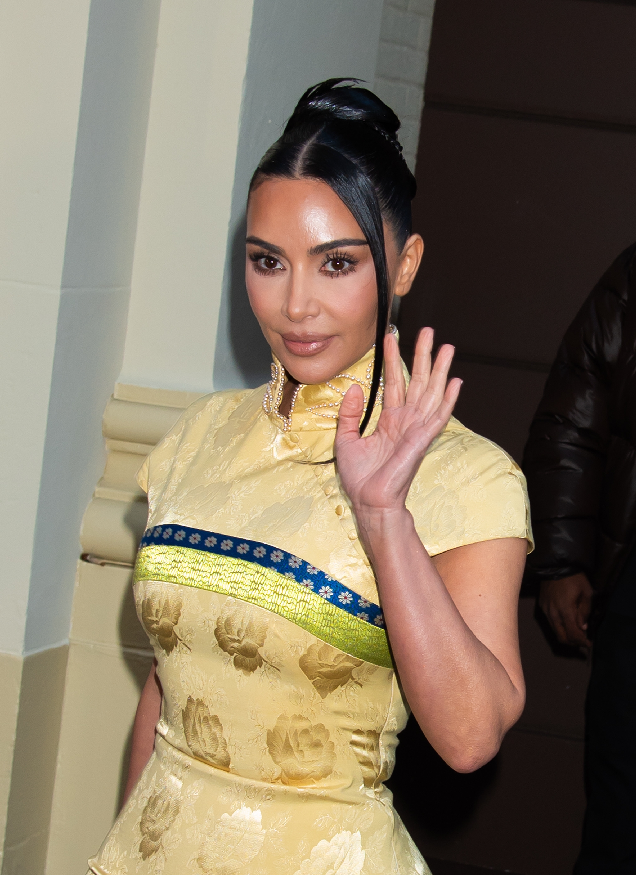 kim kardashian wears a yellow dress and waves to paparazzi