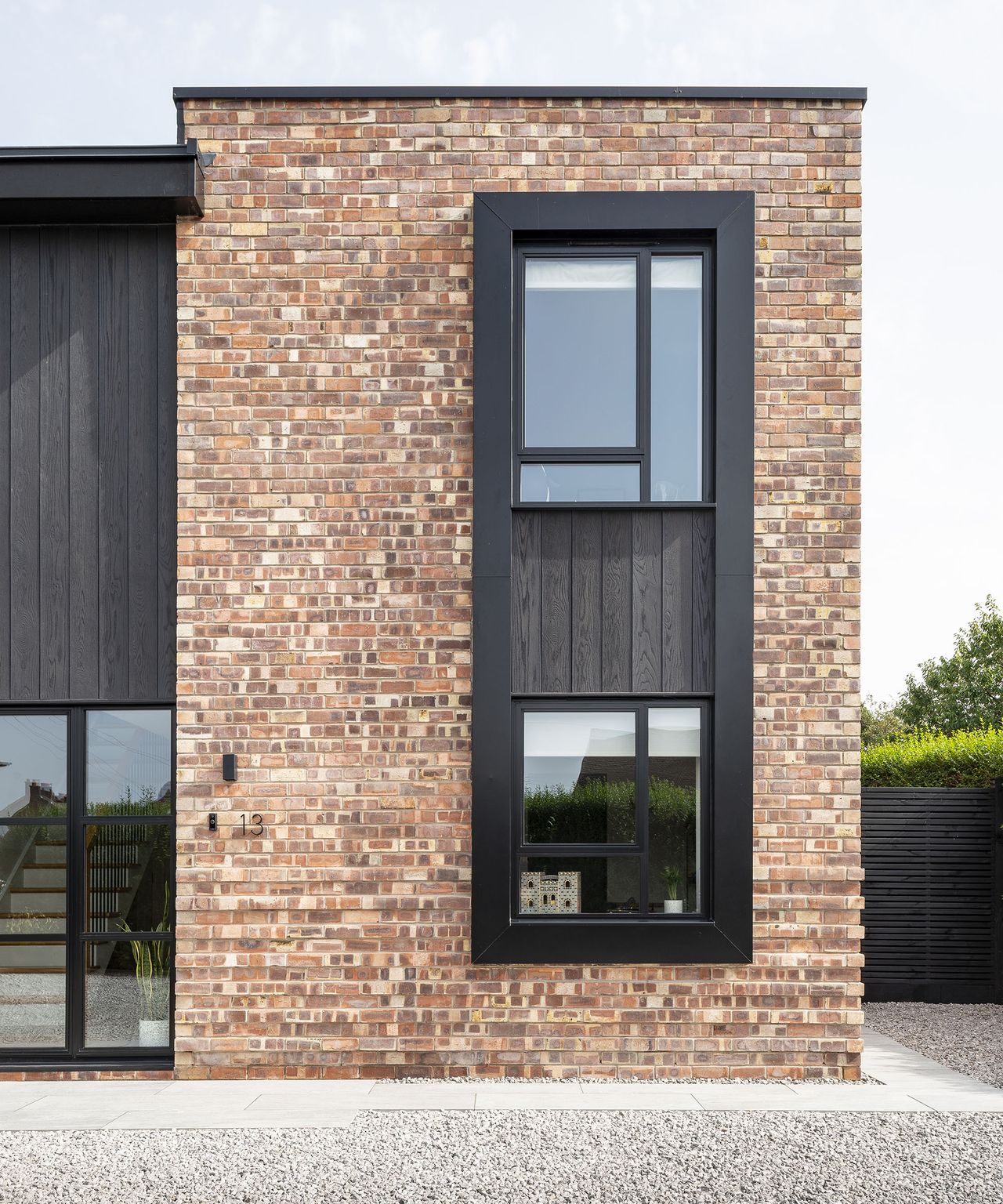 A house renovation with a flat roof and red brick timber cladding