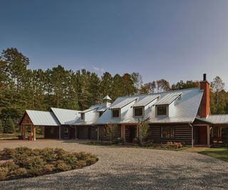 A chalet-style house in Canada with log cabin walls and a pitched slate roof