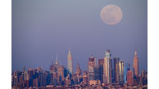 The Super Pink Moon rises over the Manhattan skyline on April 26, 2021.