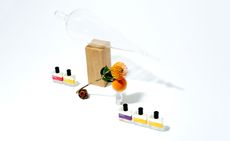 Five small perfume bottles with orange flower in the middle