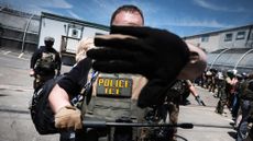 ICE agents stand guard in front of protesters outside Delaney Hall migrant detention center in New Jersey