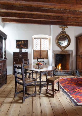 snug with dining table and fire lit in 17th century home