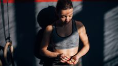 Woman in gym wear holding nuts in a cupped palm