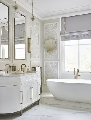 An example of spa bathroom ideas showing wallpaper panels in a bathroom with white sanitaryware, brass fixtures and fittings, and a marble floor