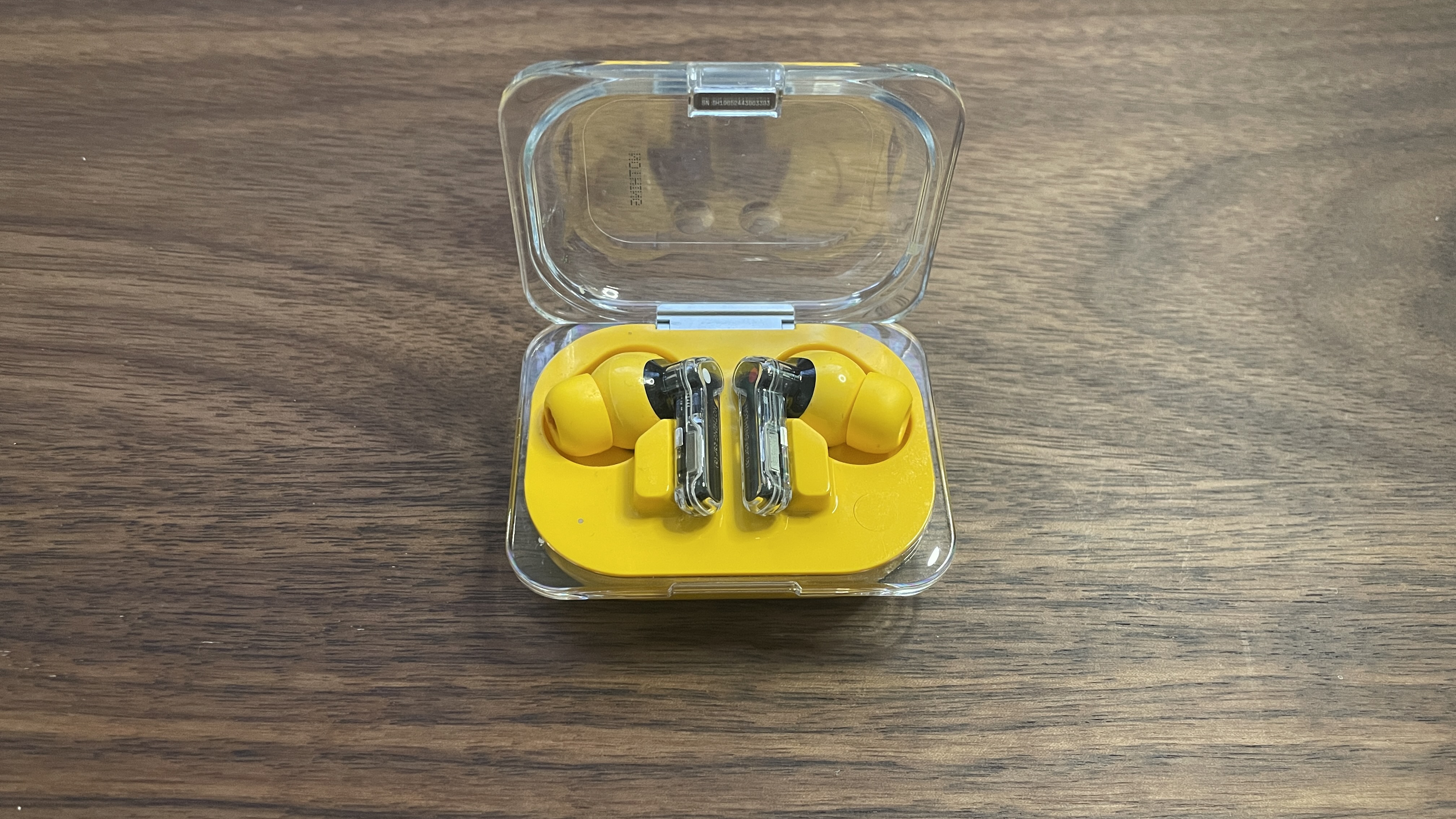 Nothing Ear (a) earbuds in their charging case with the lid open