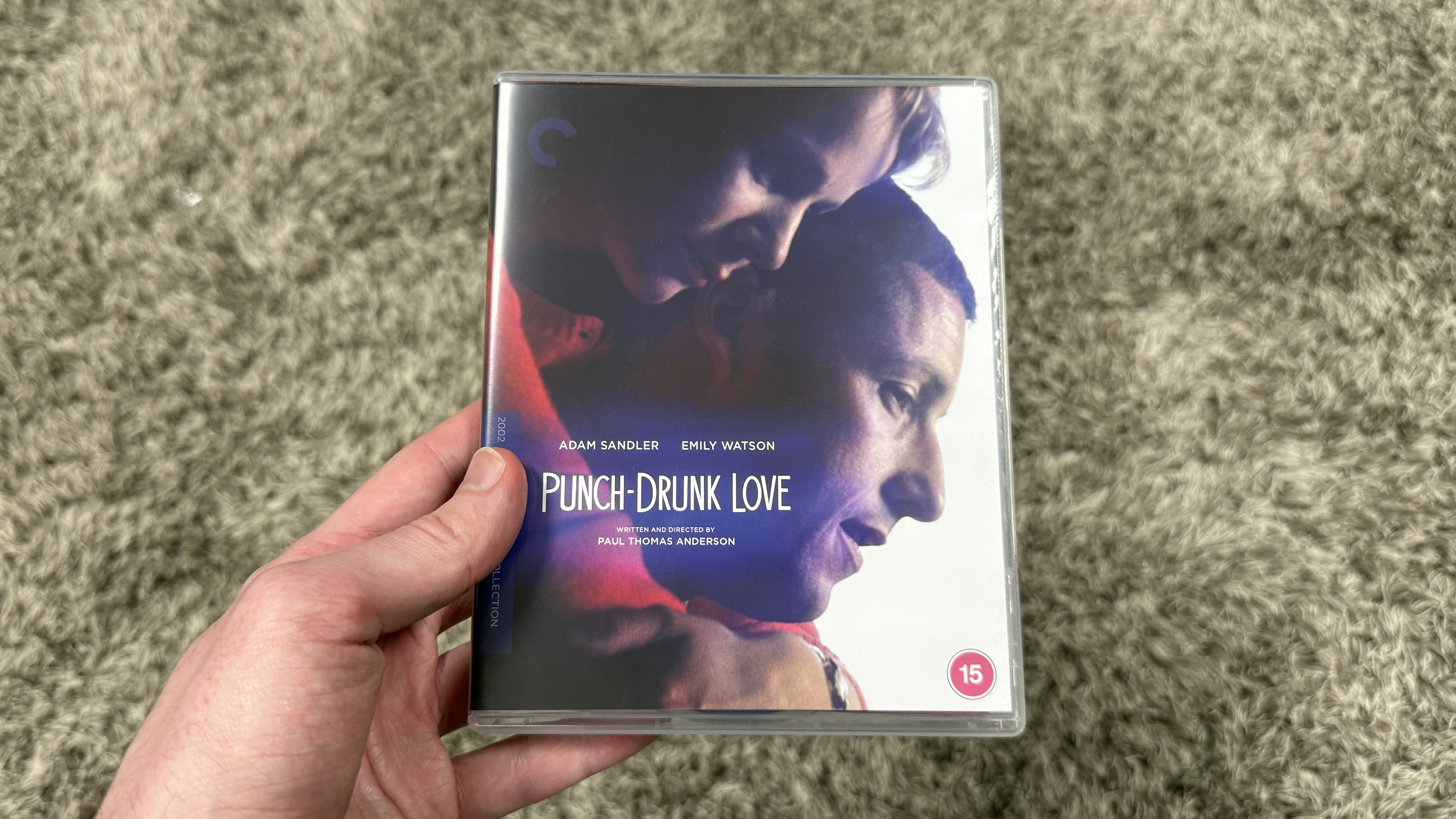 A man's hand holding the Punch-drunk Love 4K Blu-ray