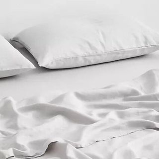 A white flat sheet and pillow case on a white background