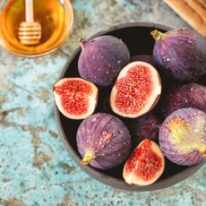 fresh figs in bowl, honey in background 