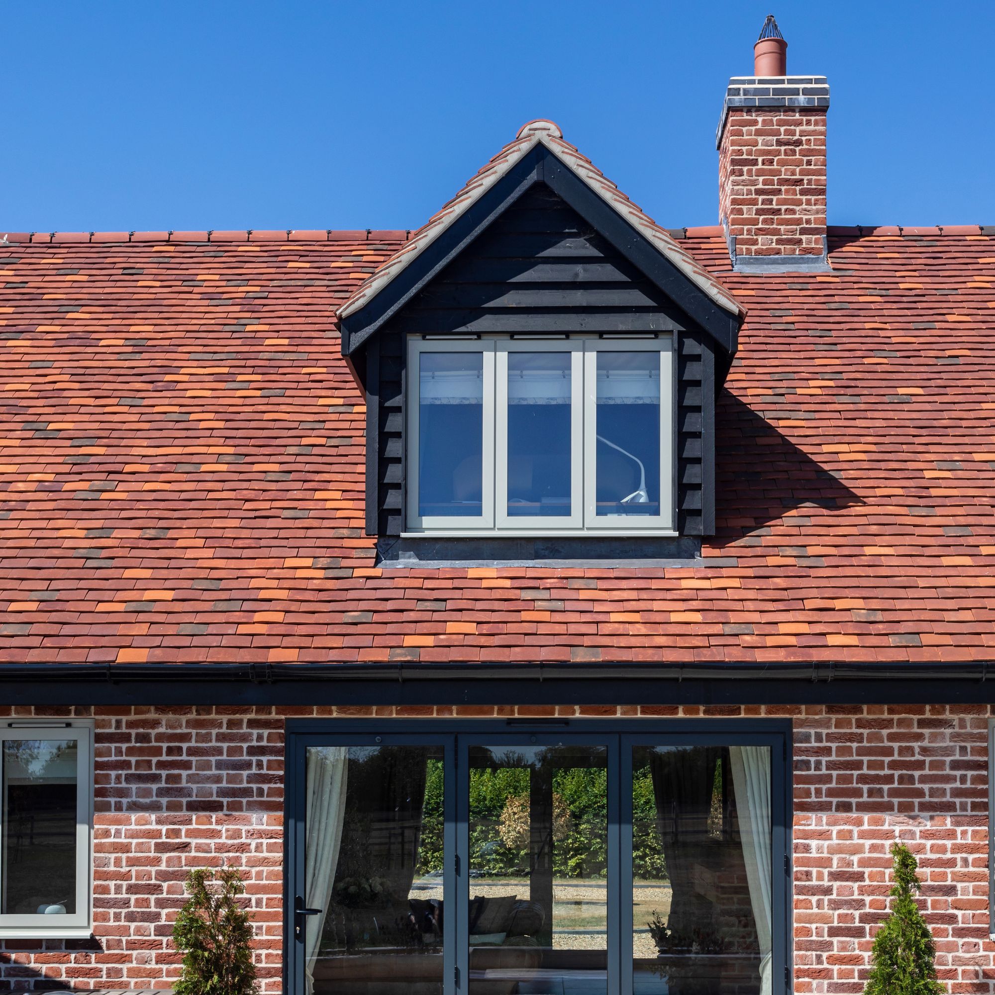 Dormer window on a tiled roof with chimney