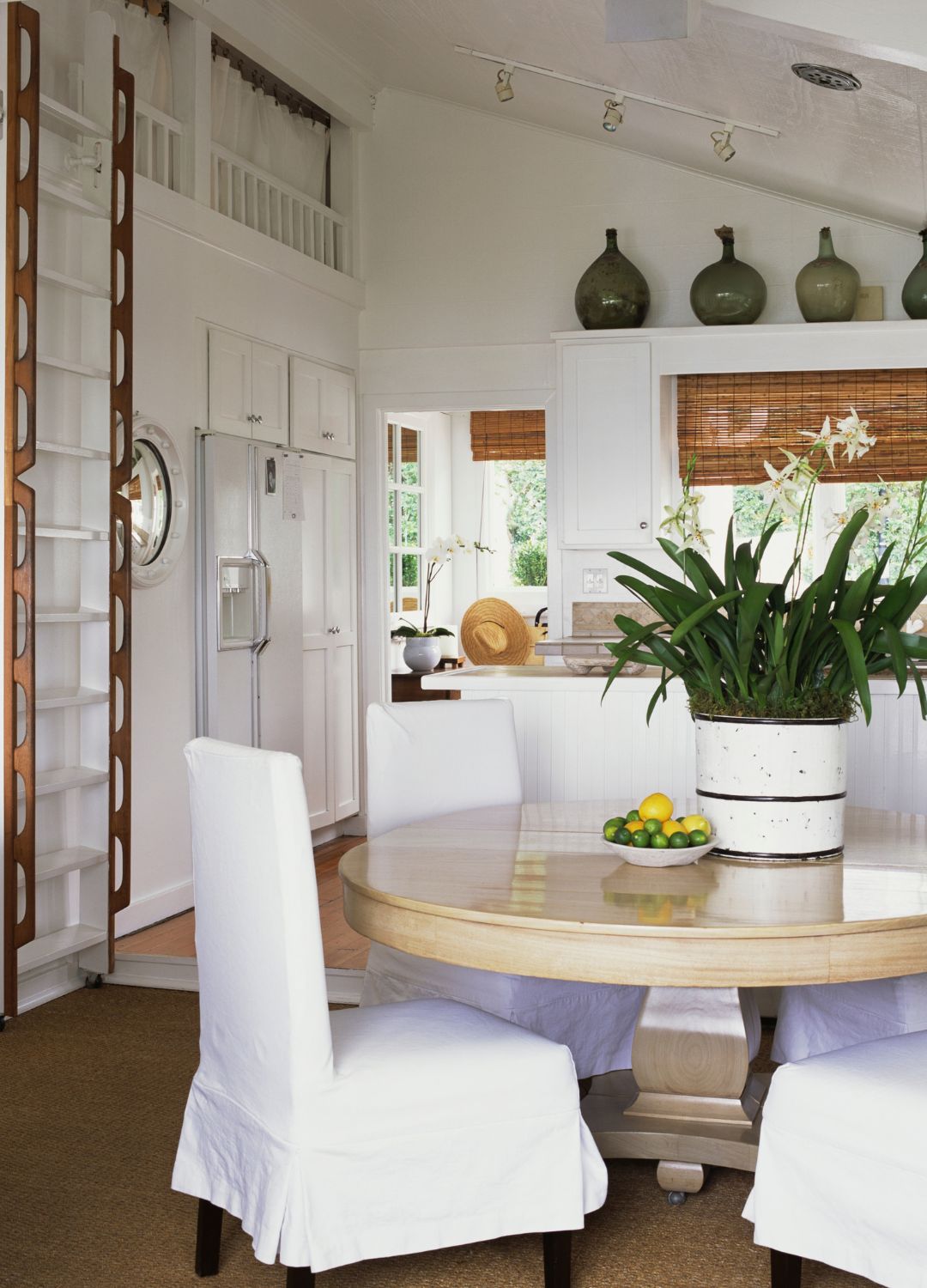 picture of netural white cabin style home with laddre and dining table