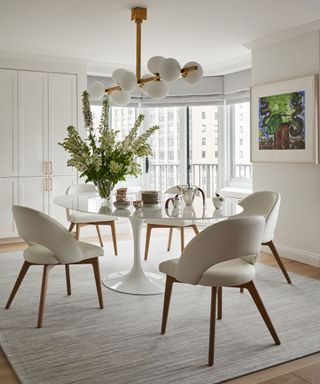 neutral dining room with oval table and statement light fitting