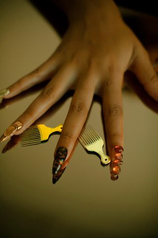 Long nail polished hands with small afra combs