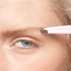 Best tweezers - close up of a woman using tweezers to pluck her eyebrows