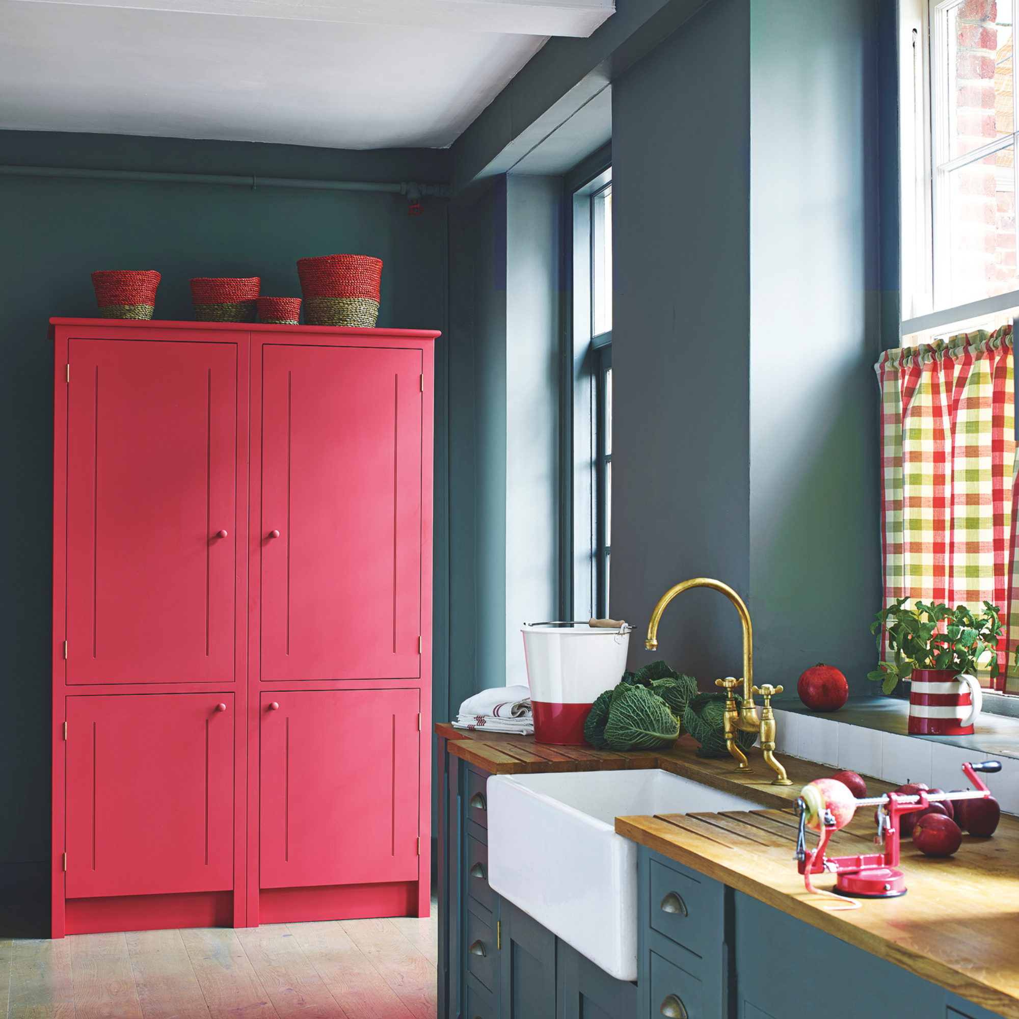 Cherry red cabinet in a navy kitchen.