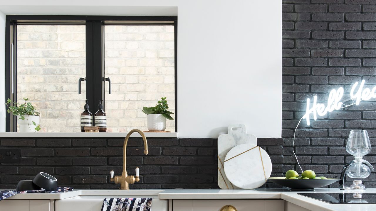 Black and white kitchen with window and gold tap