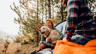 couple camping with their golden retriever