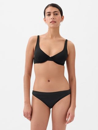 seorang model mengenakan atasan bikini balconette hitam dengan bawahan bikini bertingkat rendah yang serasi