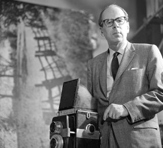 Philippe Halsman poses with his camera in his 67th St. home and studio on an episode of the CBS celebrity interview program 'Person to Person,' New York, New York, April 15, 1960